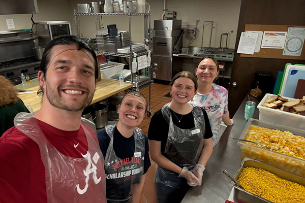 Four TEKLYNX employees volunteering at a local food bank providing dinner service